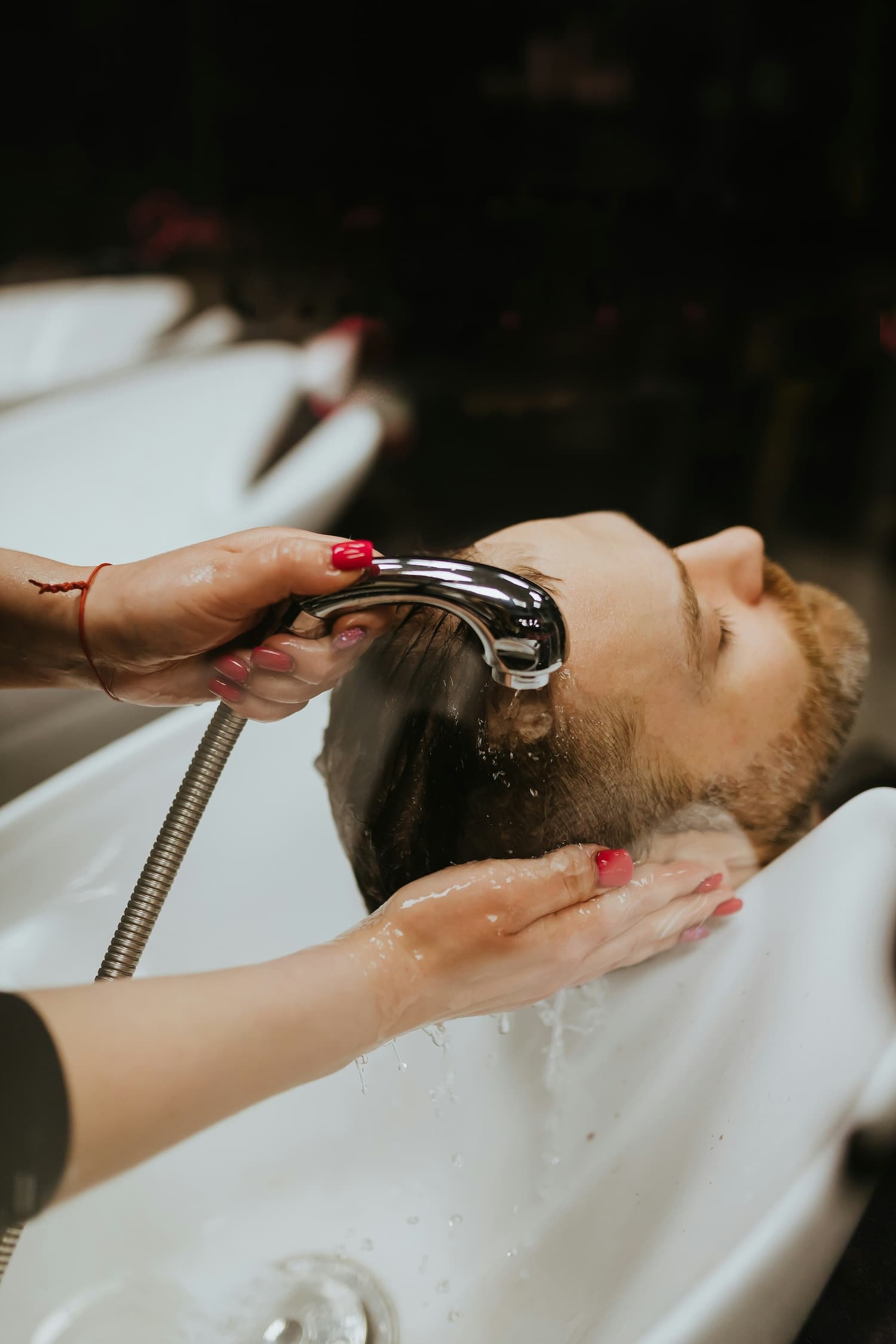 Barber washing client's hair
