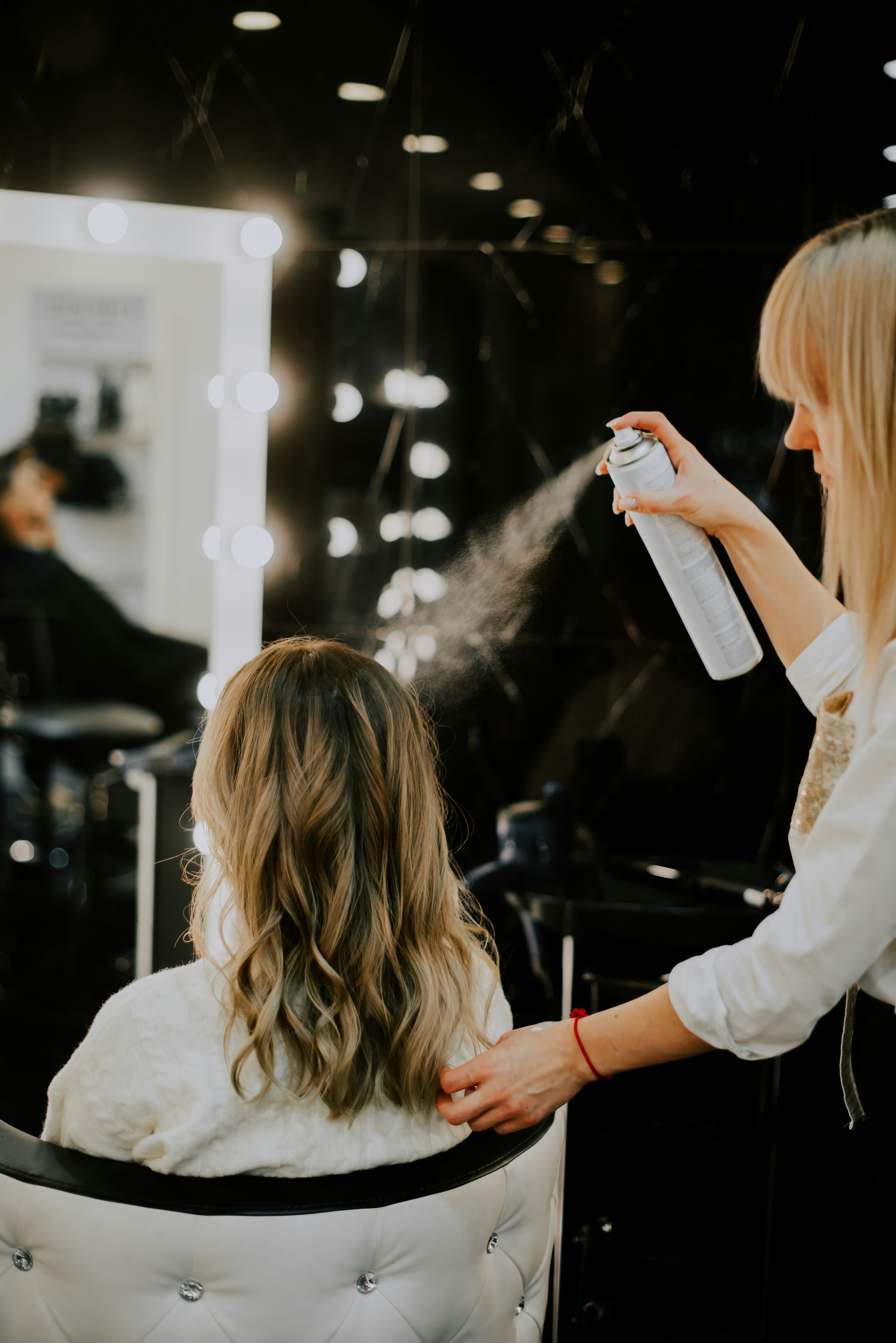 Hair stylist styling client's hair in a modern salon